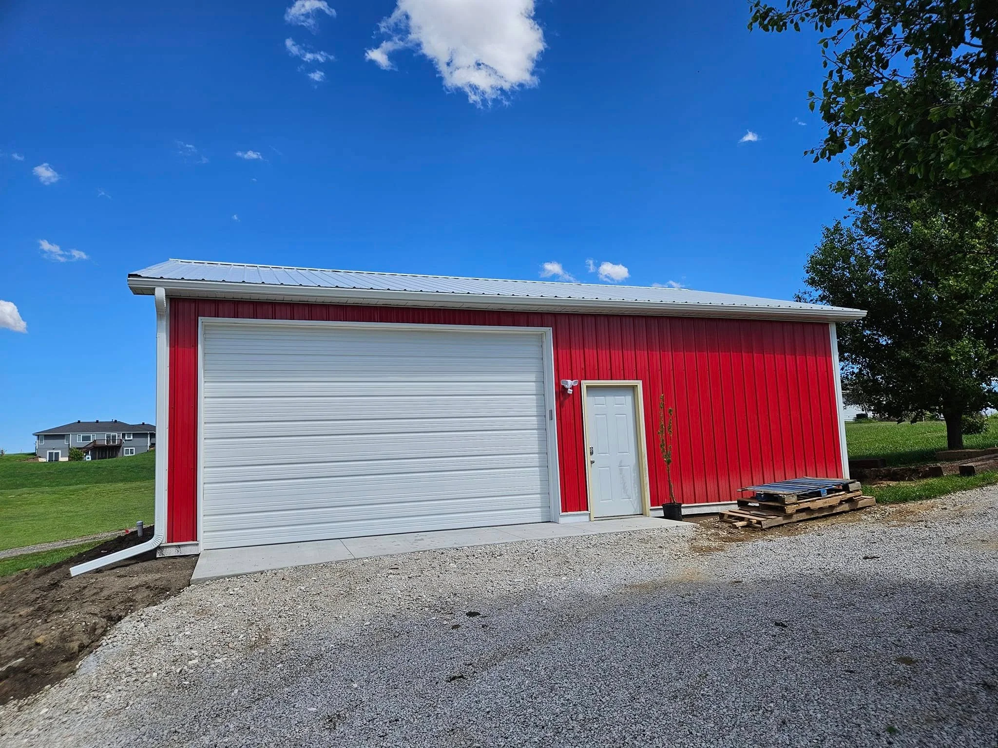 New gutters installed on a red pole barn