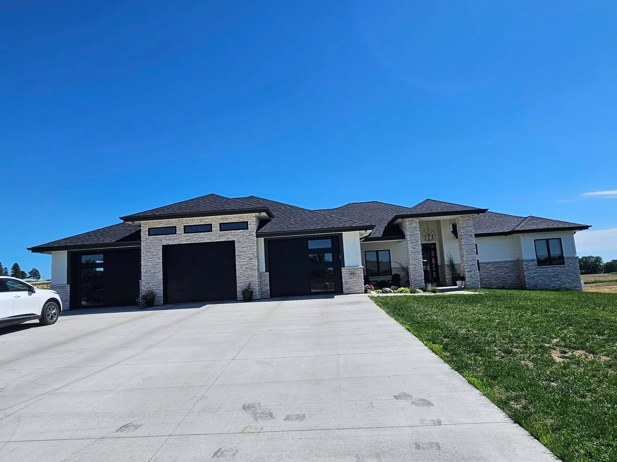 Large two-story stone and stucco home with new gutters